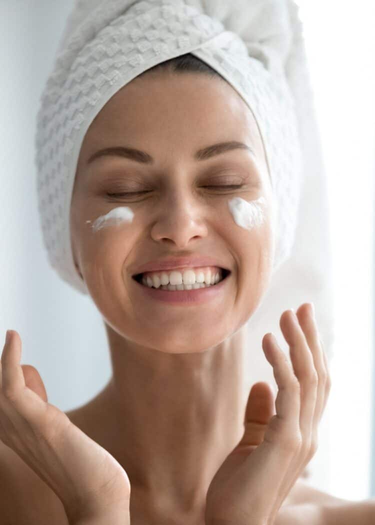 Woman smiling with moisturizer on her cheeks