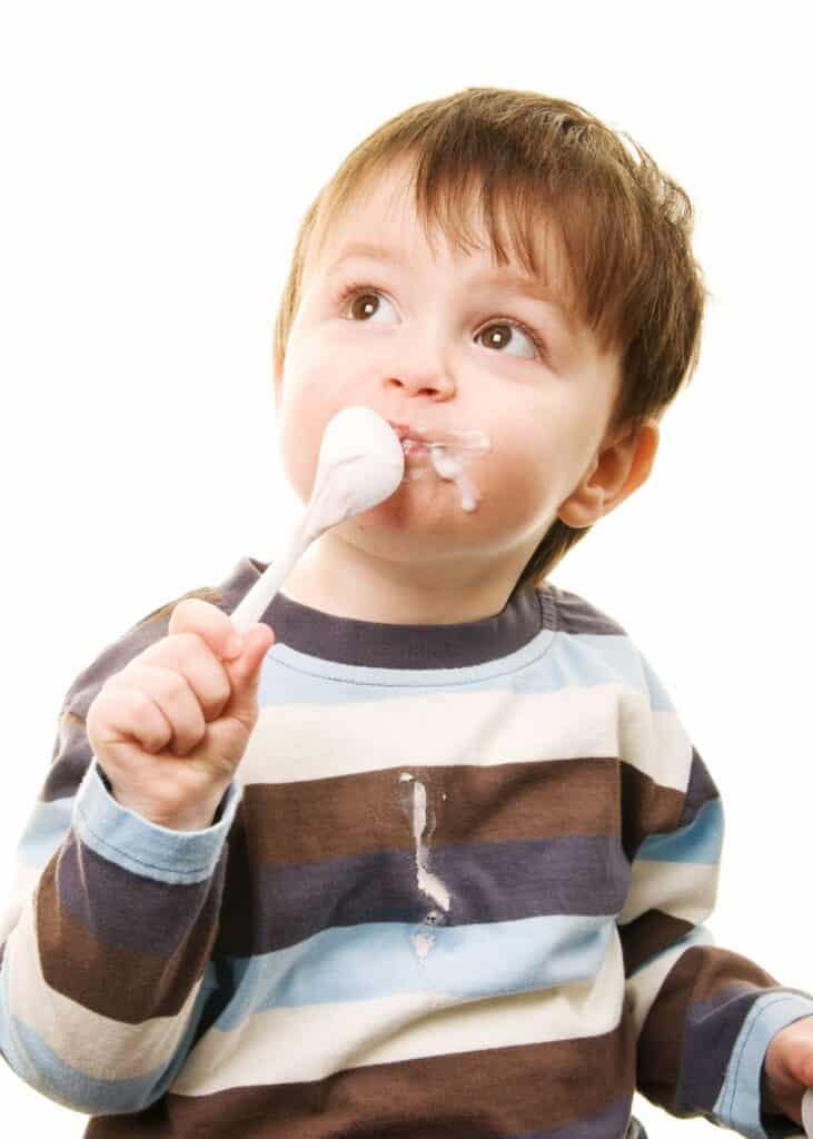 Boy looking up with spoon on his mouth