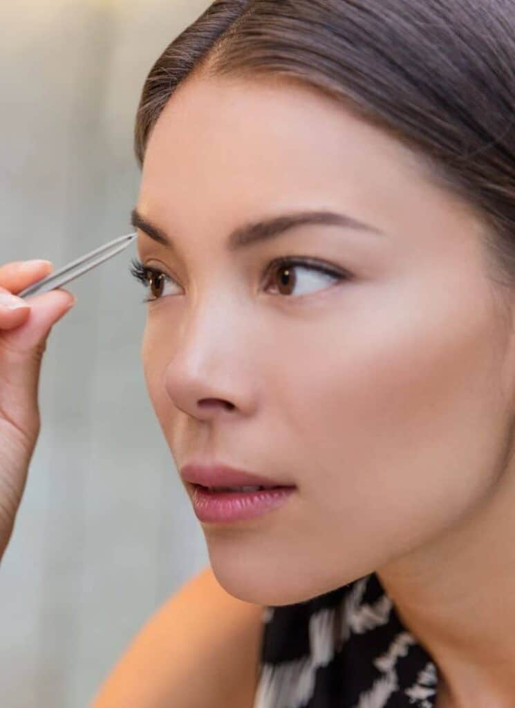 woman plucking eyebrows